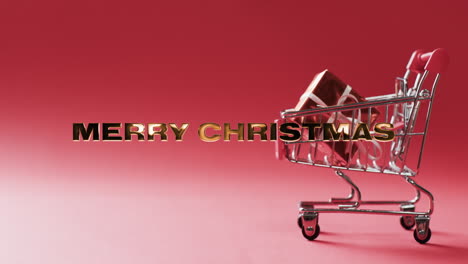 Texto-De-Merru-Shristmas-En-Oro-Sobre-Regalos-En-El-Carrito-De-Compras-Sobre-Fondo-Rojo