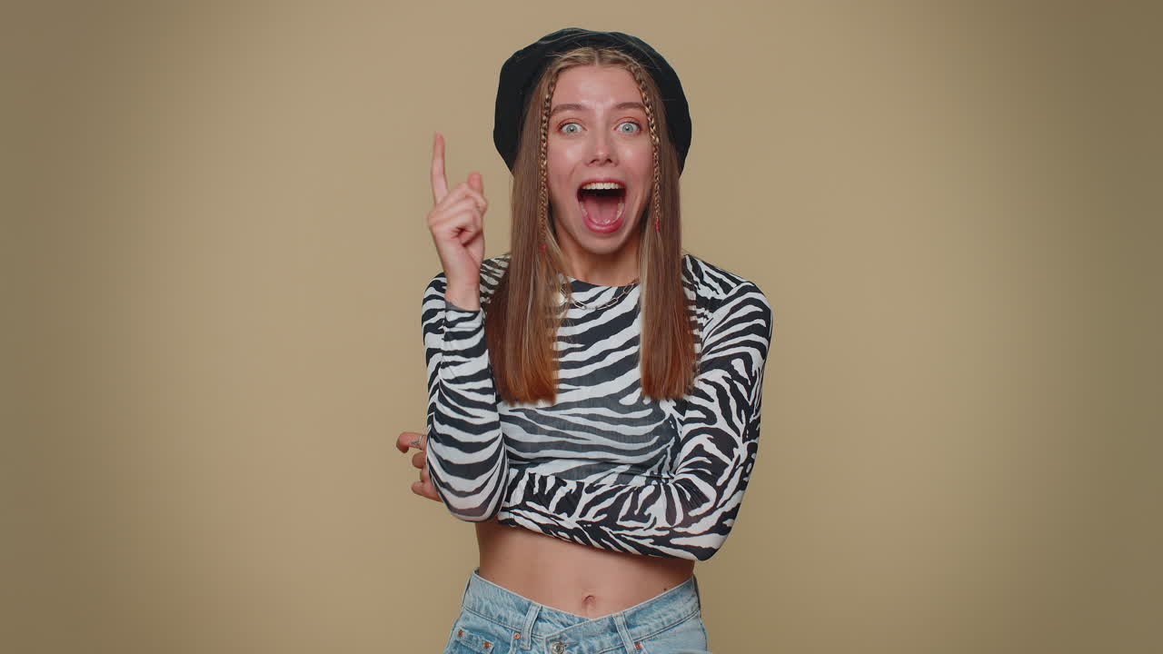 mujer inspirada señalando con el dedo con la boca abierta, teniendo una buena idea, plan, inicio eureka motivación