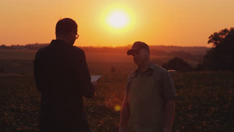 Un-Joven-Empresario-Se-Comunica-Con-Un-Agricultor-En-El-Campo