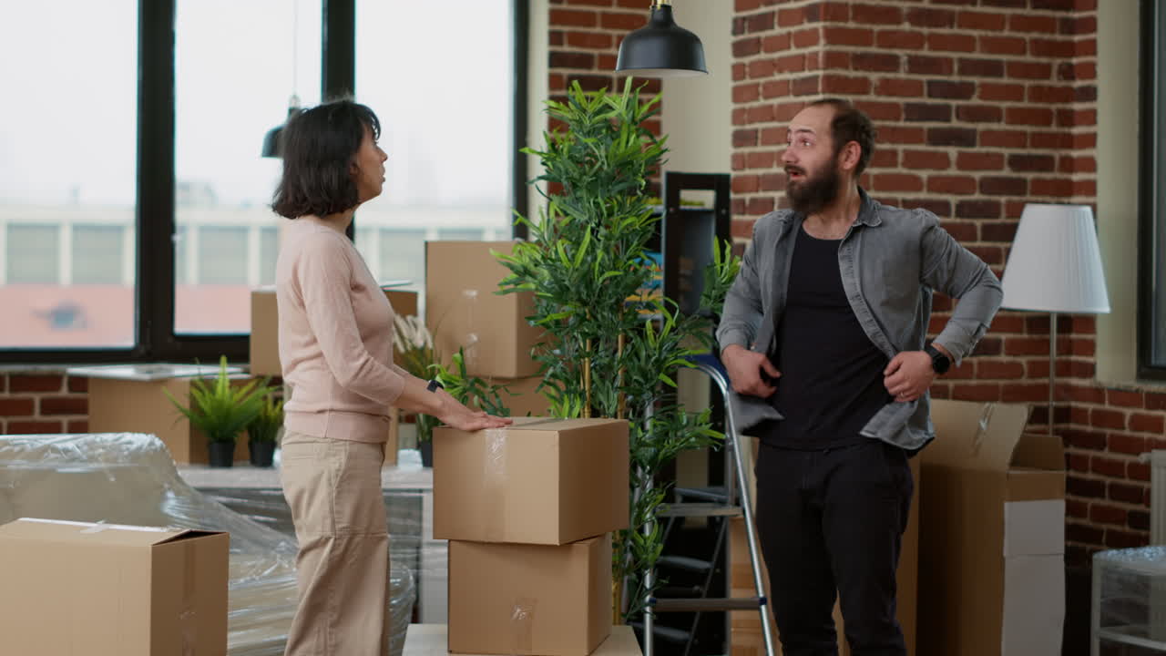 Married couple unpacking furniture and decor in new household