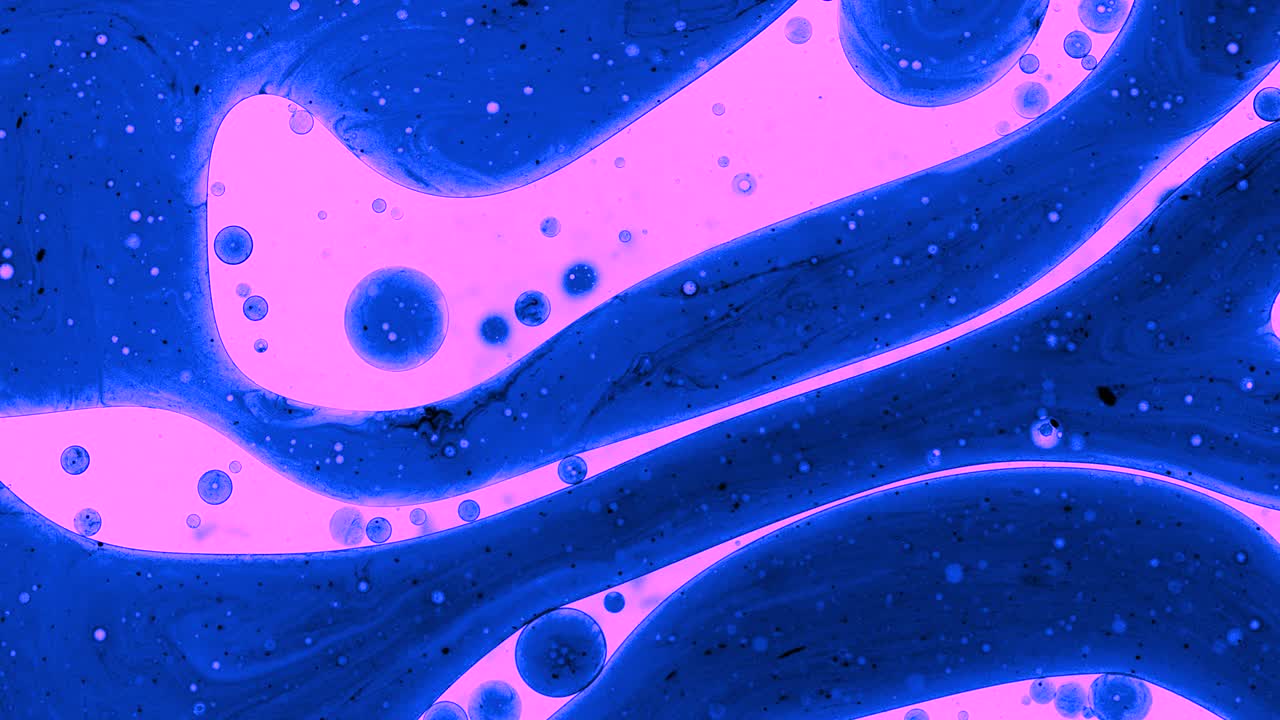 Colorful oil drops floating on water surface, top view. Fantastic abstract background. Bright bubbles moving and spreading. Close up 4k video of weird liquid structures. Scientific chemical experiment