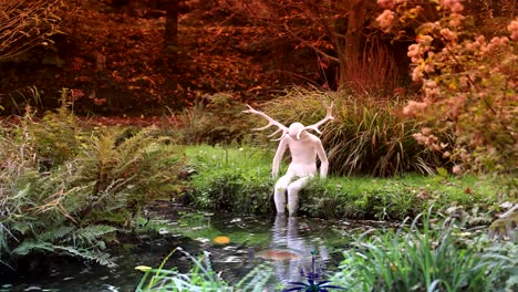 fantasy scene with a humanoid with deer antlers sitting with its feet in a lake with fish. suddenly a strange bird with teeth appears in the scene.