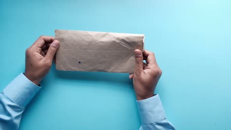 hands holding and exchanging a brown envelope with cash