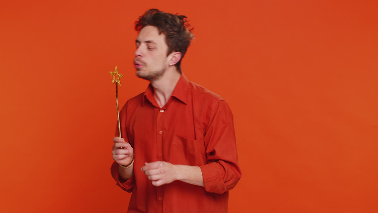 Magician wizard young man gesturing with magic wand making wish come true casting magician spell