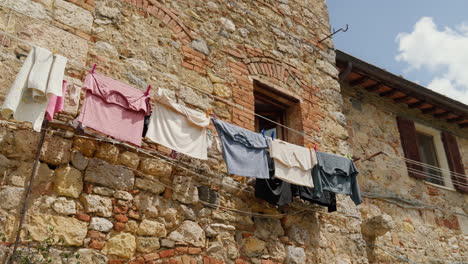 rustic italian house with laundry hanging to dry under blue sky