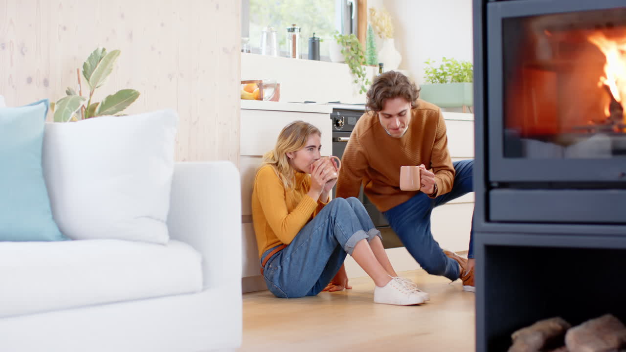 Couple sitting on kitchen floor enjoying coffee, sharing warm holiday moments, copy space