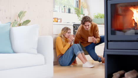couple sitting on kitchen floor enjoying coffee, sharing warm holiday moments, copy space