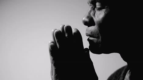 man-praying-to-god-with-hands-together-on-grey-background-stock-footage