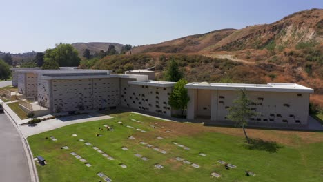 Aerial-low-panning-shot-of-a-large-stone-mausoleum-at-a-California-mortuary