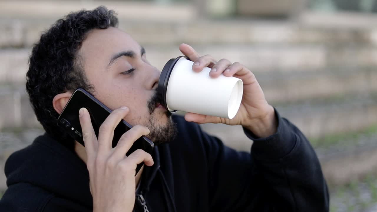 hombre alegre hablando por teléfono inteligente en la calle