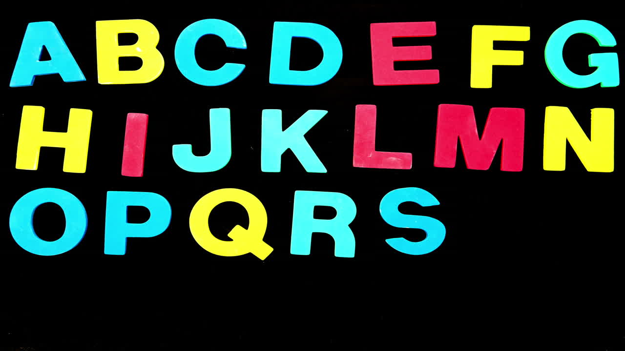 Colourful alphabet appearing on black background