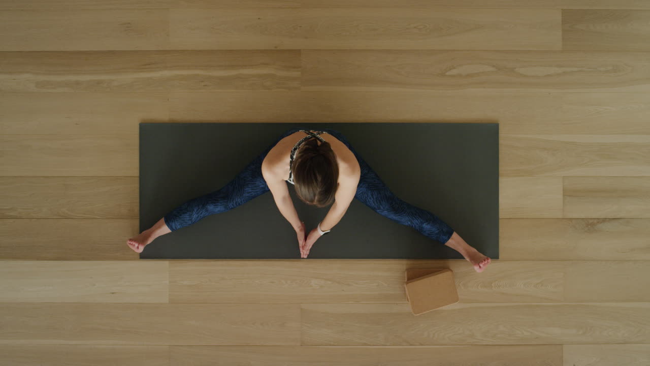 vista superior de una mujer de yoga practicando posturas en un estudio de entrenamiento disfrutando de un estilo de vida saludable practicando meditación en una colchoneta de ejercicios