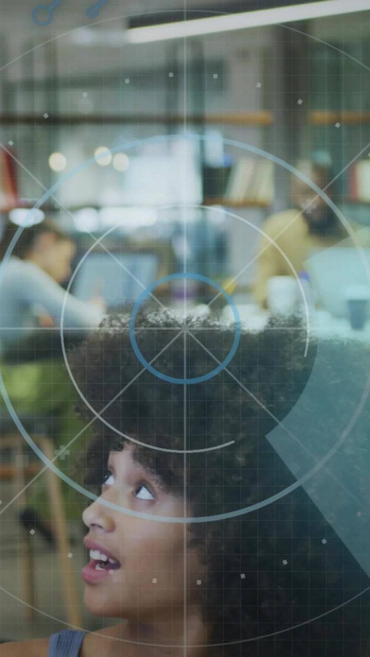 Video verticale: Donna che alza la testa dopo un prompt HUD in un ufficio tecnologico, con un mirino HUD che evidenzia il viso.