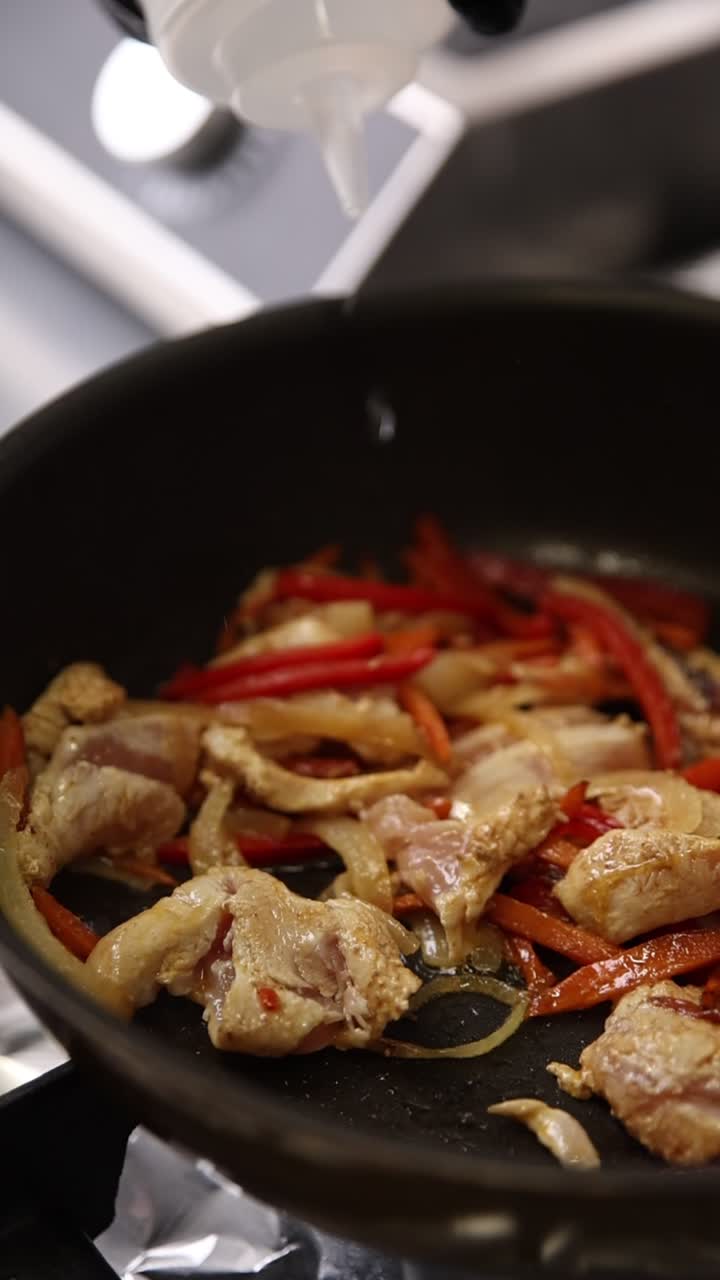 Aggiunta di liquido a pollo e verdure in cottura in padella