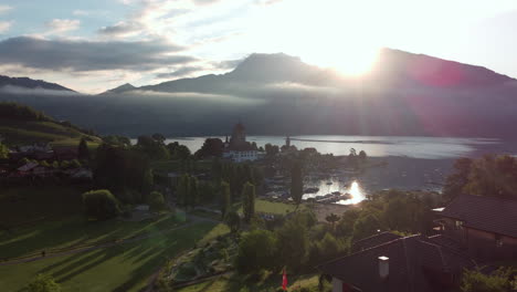 Aerial-view-orbiting-over-the-castle-Schloss-Spiez-on-the-shore-of-lake-Thun