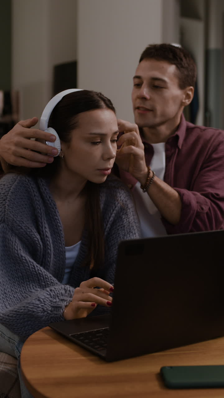 Couple Listening to Music and Using Laptop at Home