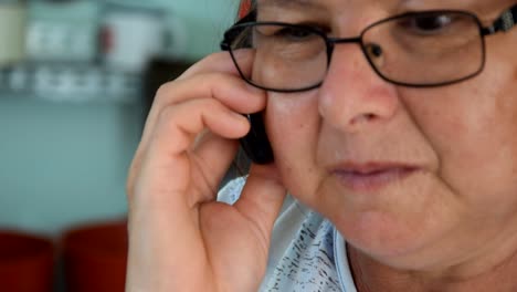 mature female listening intently on mobile phone