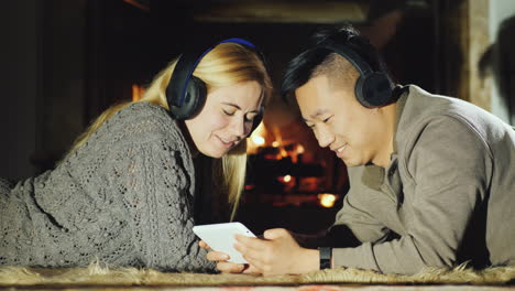 Young-Couple-Sharing-Tablet-By-Fireplace-01