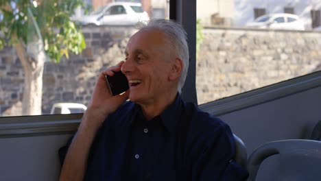 senior man talking on mobile phone while travelling in bus 4k