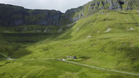 Irish-Highland-Horizons:-Aerial-Departure-from-Gleniff-Horseshoe-on-a-Sunny-Day,-Mountains-in-Green-Splendor,-and-Shadows-Cast-by-Clouds