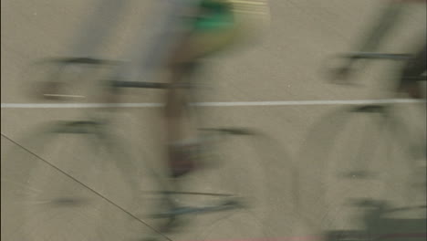 bicycle riders pass by in a blur