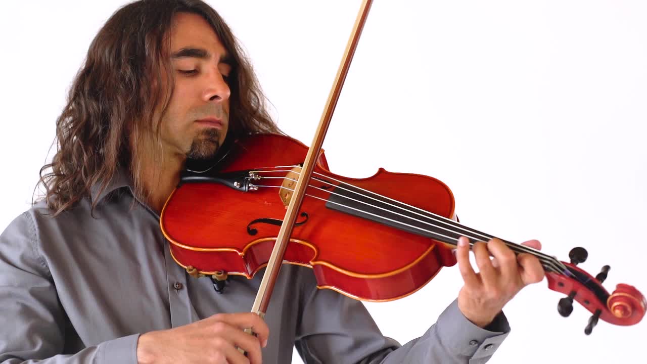 흰색 배경에서 느린 동작으로 빨간색 비올라 악기를 연주하는 긴 갈색 머리를 가진 히스패닉 남성 음악가
