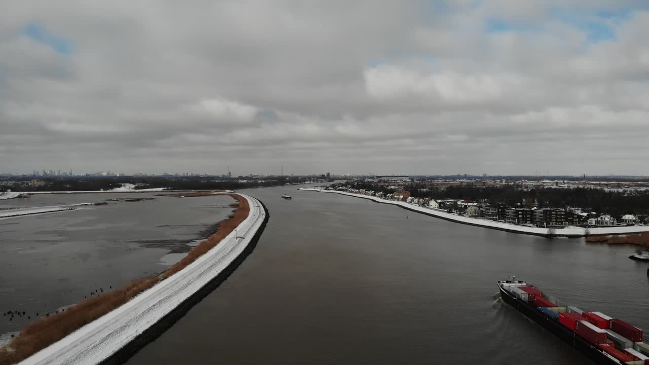 Industrial Ship With Containers Sailing On Serene Noord River Under Cloudscape During Winter In South Holland, Netherlands. - Aerial Wide Shot