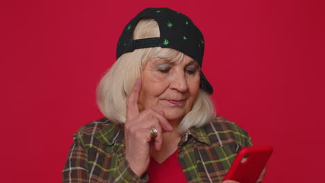 mujer de edad avanzada que utiliza el teléfono móvil escribiendo publicaciones en la web mensajes de texto navegando adicción a las redes sociales