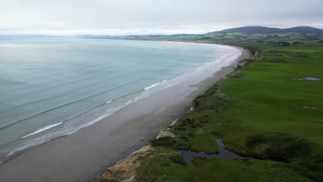 waves hit the shore of a monkey island in beach area, new zealand