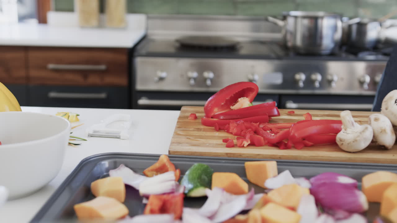 una feliz pareja de lesbianas caucásicas preparando comida en una cocina soleada