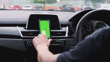 Primer-Plano-De-Un-Hombre-Usando-Un-Teléfono-Móvil-Montado-En-El-Tablero-De-Un-Auto-Filmado-En-Cámara-Lenta