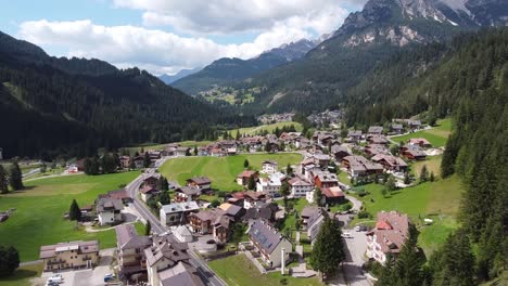 Val-Di-Fassa-En-Trentino,-Dolomitas,-Italia---Vista-Aérea-De-Un-Pueblo-De-Montaña-En-El-Valle-Verde