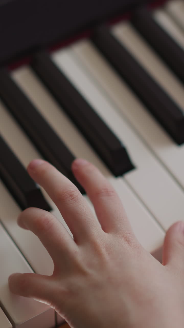 Kid musician plays piano with inspiration. Child performs composition skilfully. Pianist hands move smoothly across keyboard closeup on blurred background