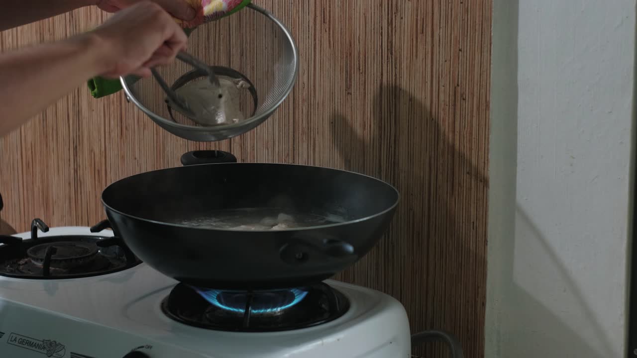 Removing Boiled Chicken from Wok with Tongs, transferring to Strainer – Medium Shot