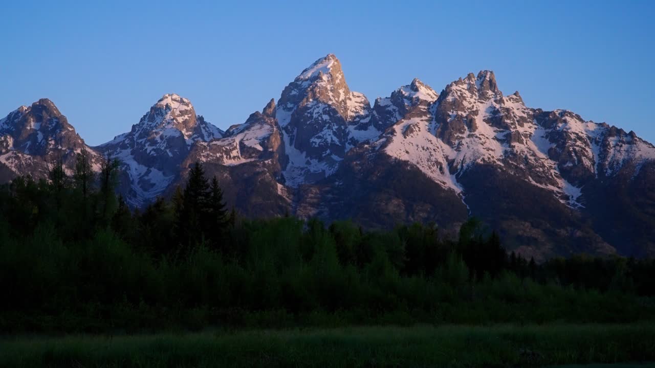 Riflesso all'alba della catena montuosa del Teton nel fiume, con movimento di tilt up, nel Parco Nazionale del Grand Teton, Wyoming.