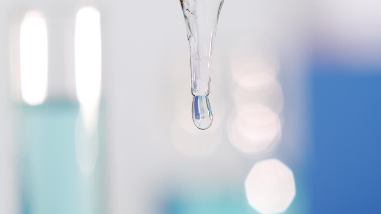 땅을 향한 피펫에서 매우 천천히 흐르면서 뻗어나가는 한 방울, 클로즈 샷