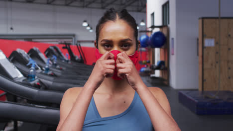 fit caucasian woman wearing face mask in the gym