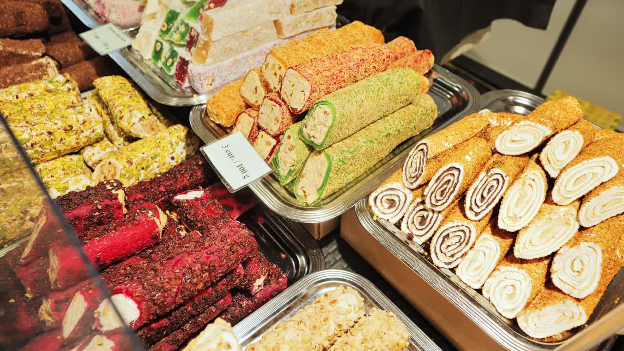 Brightly colored Turkish sweets stacked in trays offer rich textures and flavors