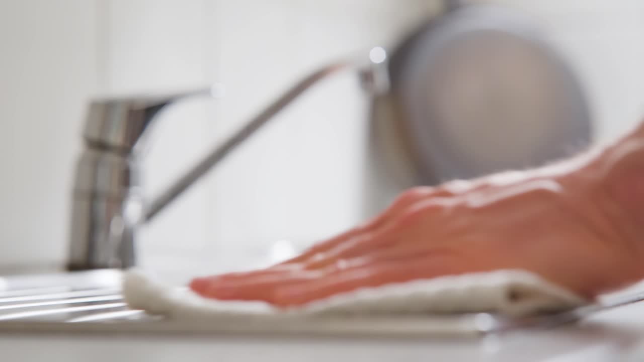 hombre limpiando una encimera de la cocina con una toalla de limpieza