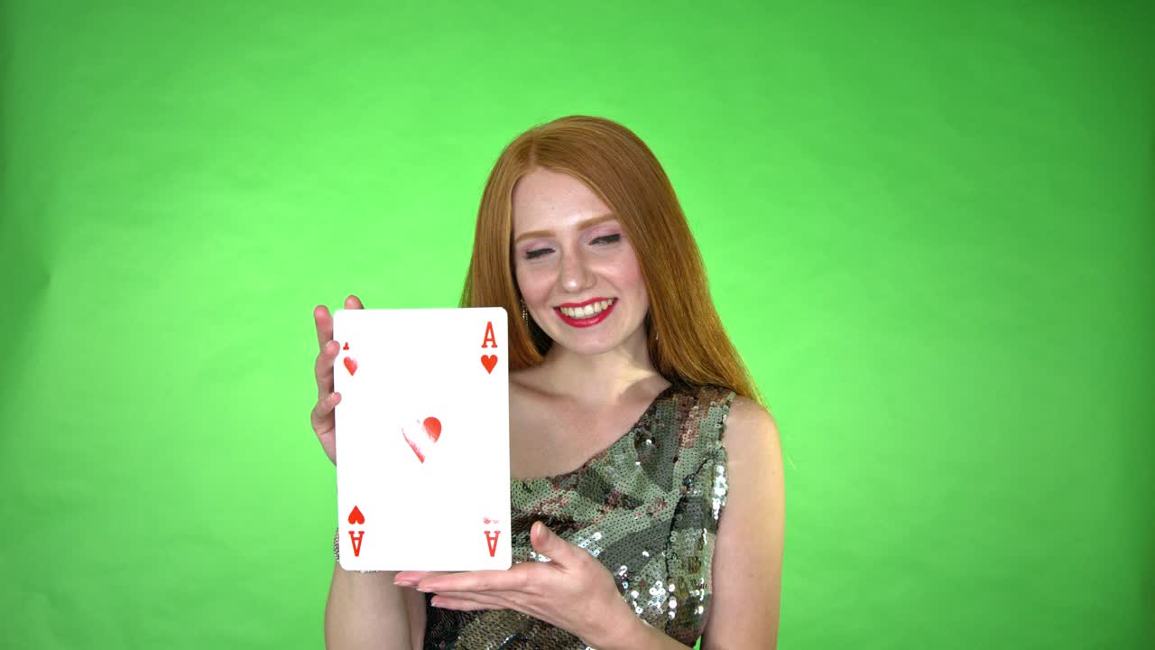 Donna dai capelli rossi attraente che tiene in mano una carta d'asso