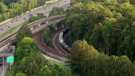 vista aérea de trenes de carga ferroviarios y automóviles que pasan por la ruta estatal de georgia 400