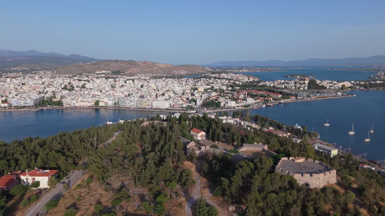 A cinematic drone reveal of Chalkida, showcasing the historic old Evripos bridge and the vibrant coastal cityscape along the Euboean Gulf.