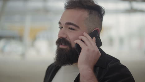 hombre barbudo tranquilo hablando por teléfono.