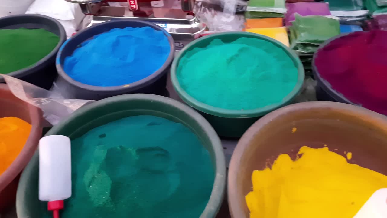 Colorful powder for sale on the festive occasion of Holi in India. Holi colorful powder, piles of powdered dyes, festival celebration herbal Holi gulaal colors in a Plastic big bowl at the roadside.