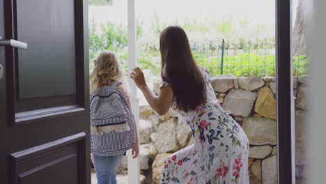 Mother-embracing-her-daughter-before-leaving-school-at-door-in-home-4k