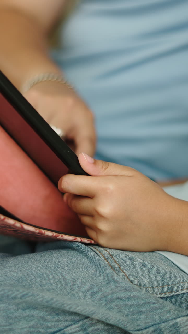 Close-up of Child's Hands Interacting with Digital Tablet Screen