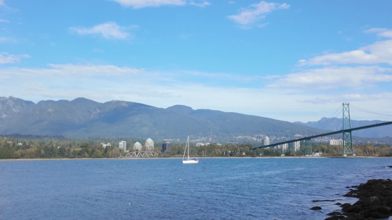 Gimbal super wide panning shot of Lions Gate Bridge from the seawall around Stanley Park in Vancouver, British Columbia, Canada. 4K