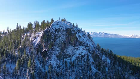 2020- beautiful revealing aerial of lake tahoe from behind a snowy mountain peak