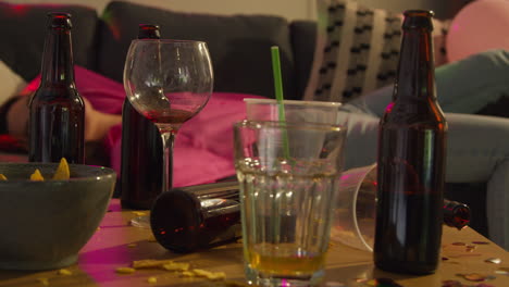 mujer tendida desmayada en el sofá después de beber alcohol en una fiesta de casa sufriendo de resaca