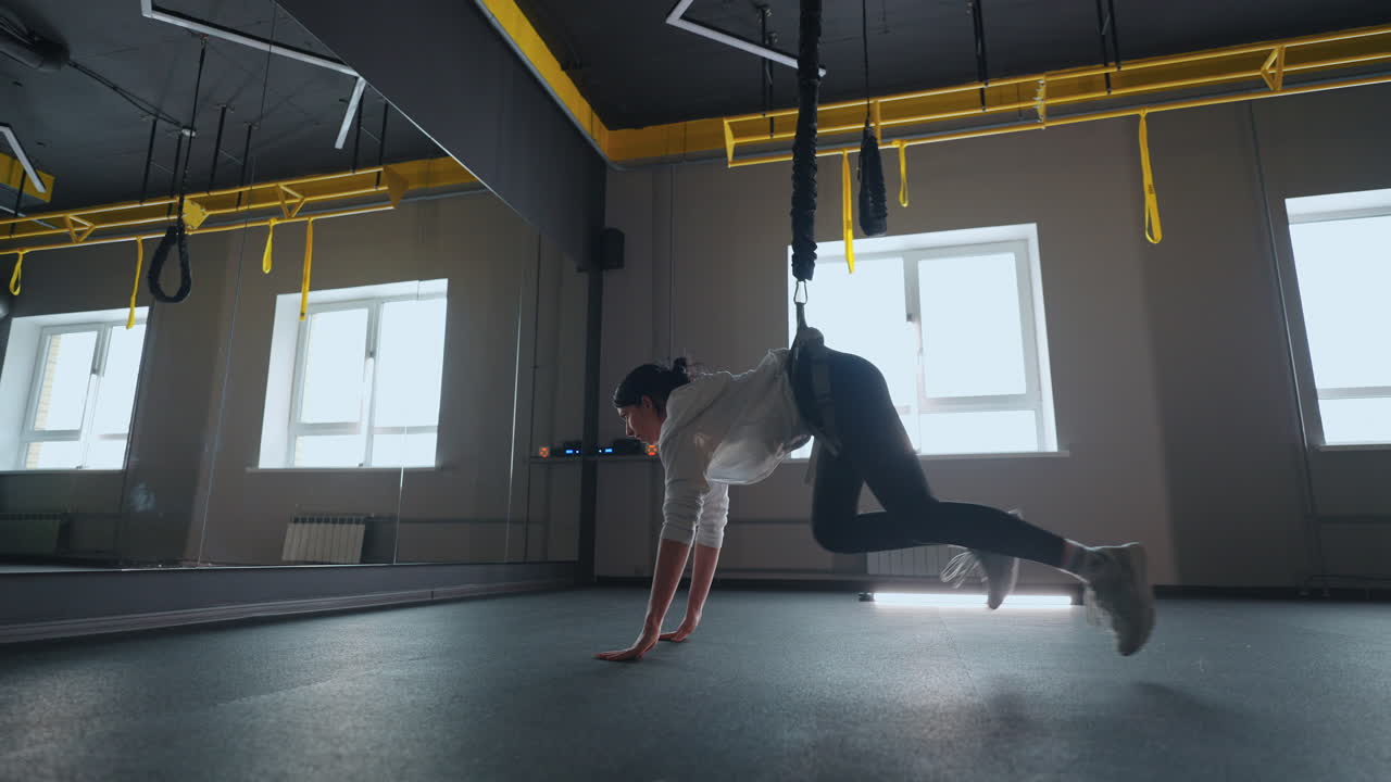 체육관 에서 현대적 인 효과적 인 서스펜션 훈련 젊은 운동 선수 는 다리 를 위한 운동 을 하고 있다